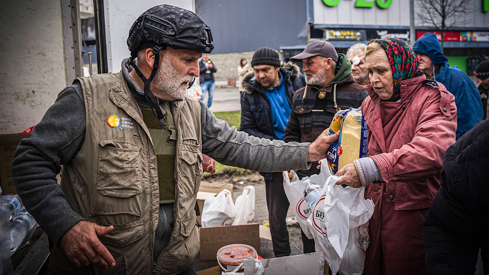  José Andrés hands a woman food in Ukraine.